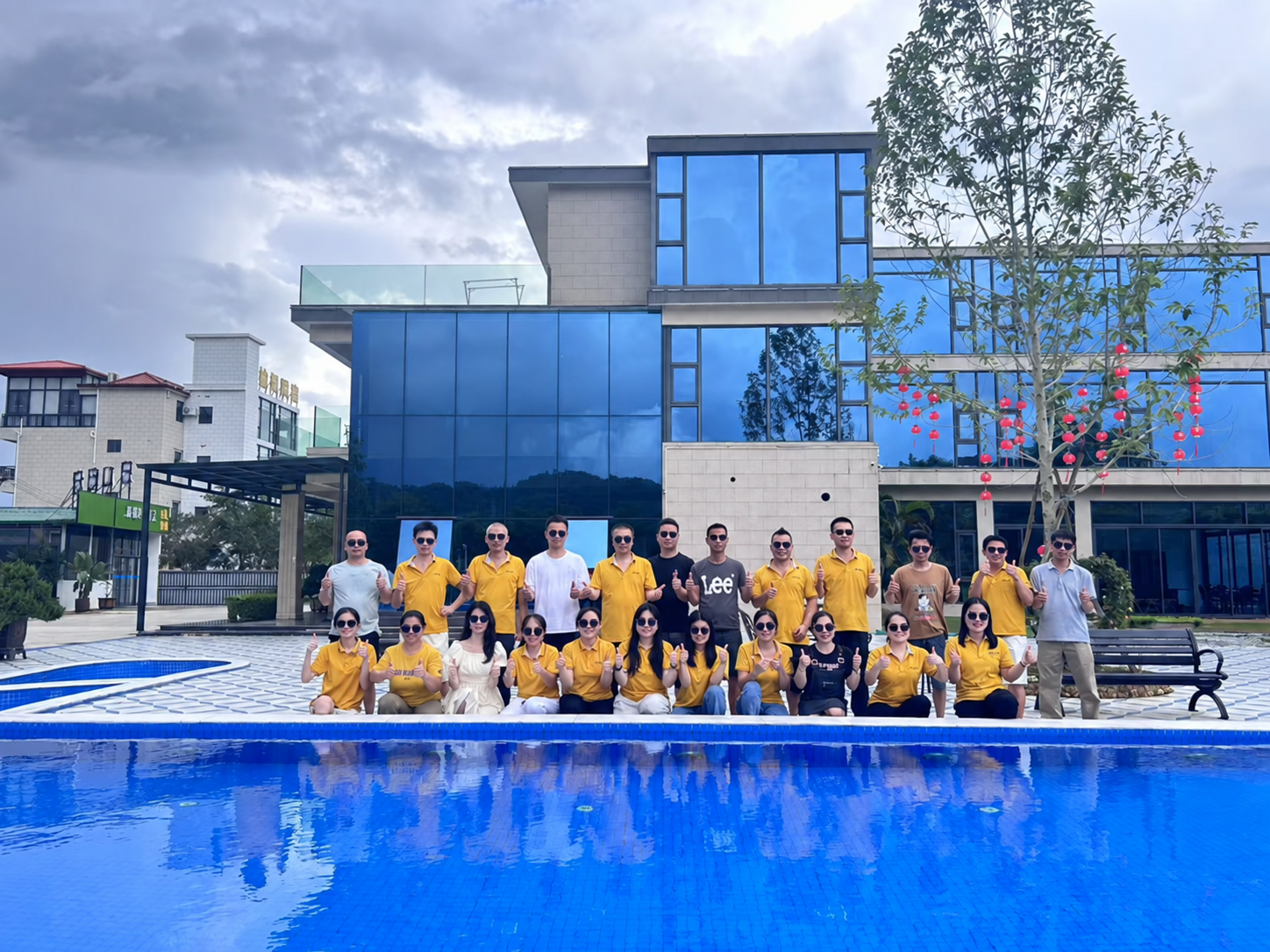 Team group photo beside an outdoor pool